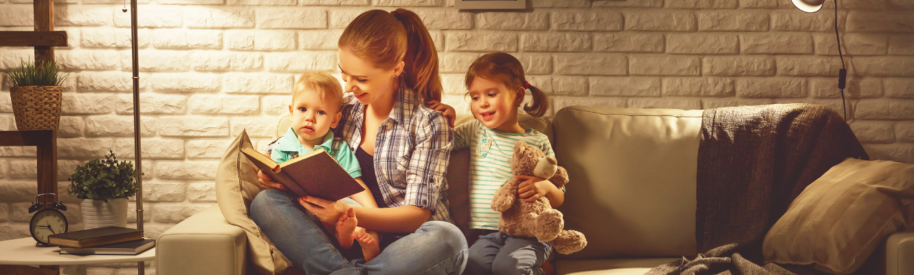 A mother reading a book to her children.