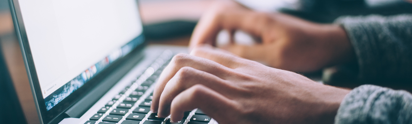 Person typing on laptop keyboard