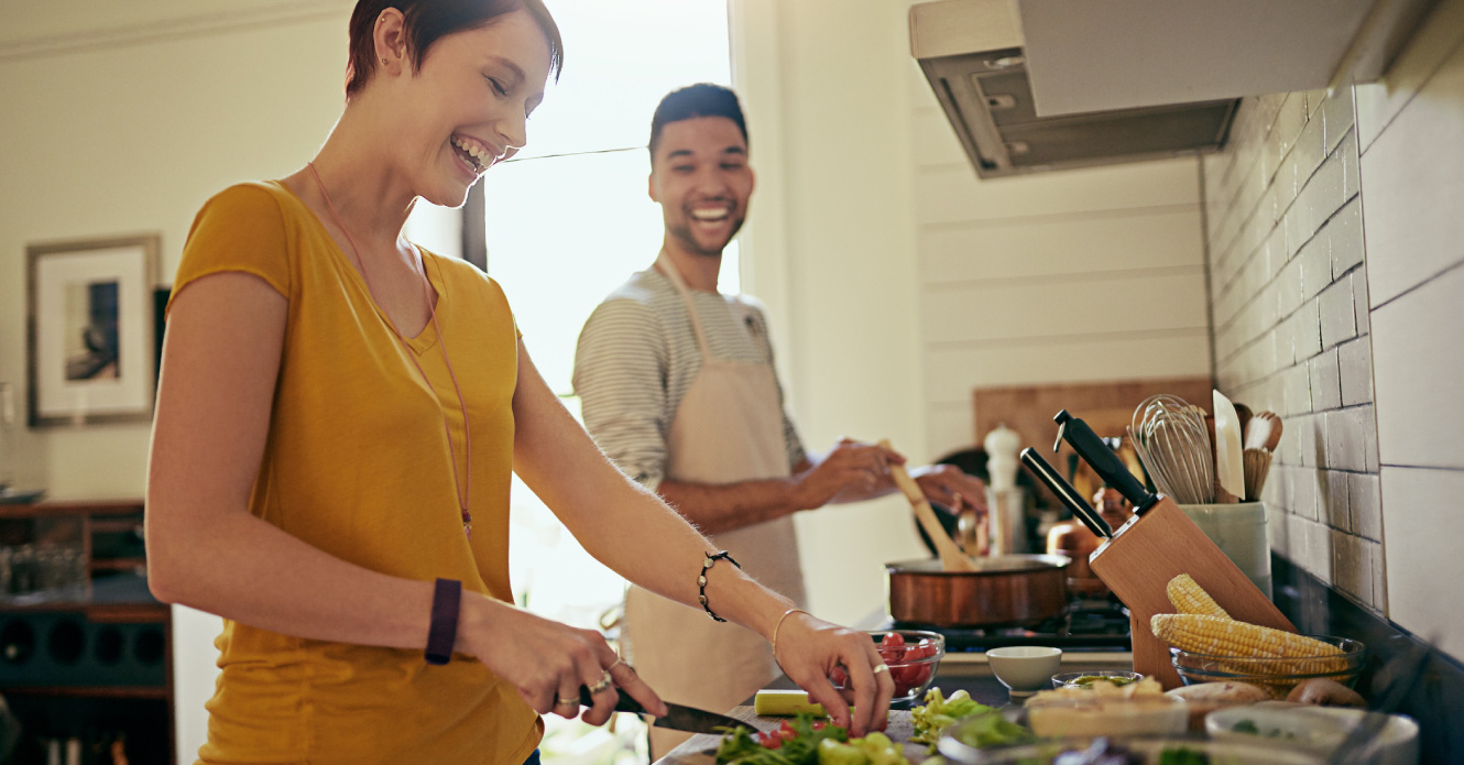 A young couple cooking together in their kitchen.