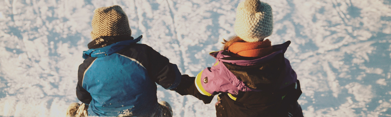 Kids playing in snow in winter attire. 