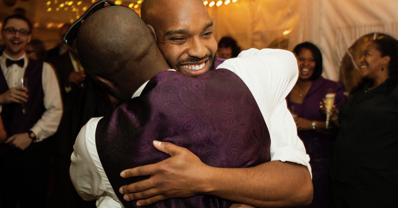 Two men hugging at a wedding