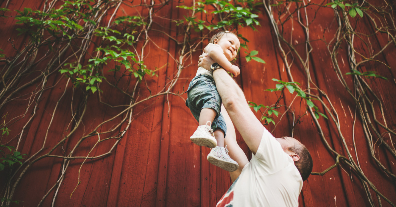 A father playing with his daughter outdoors