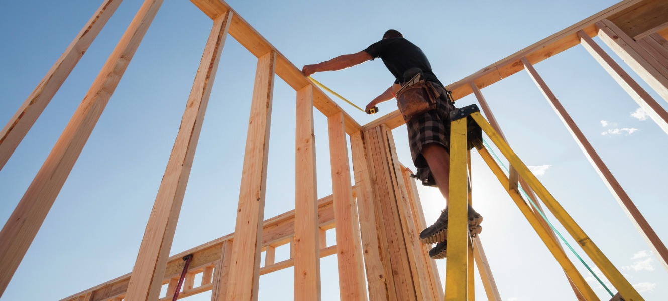 A carpenter framing a house.