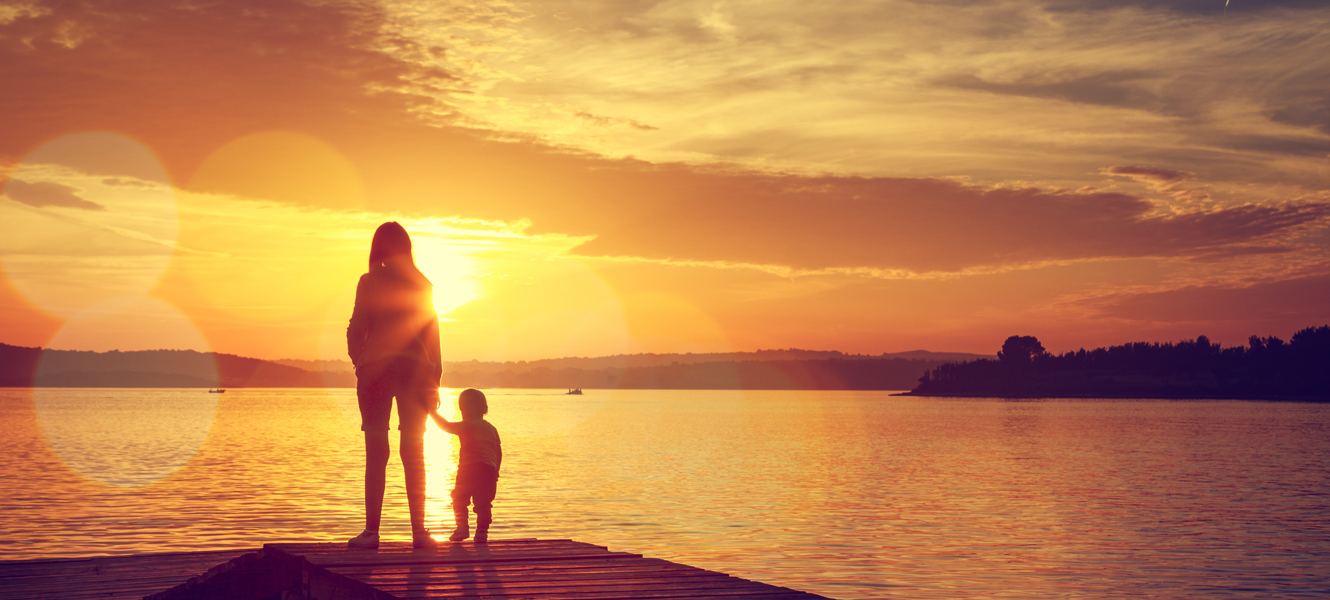 Photo of Mom and Child on river dock watching a beautiful sunset