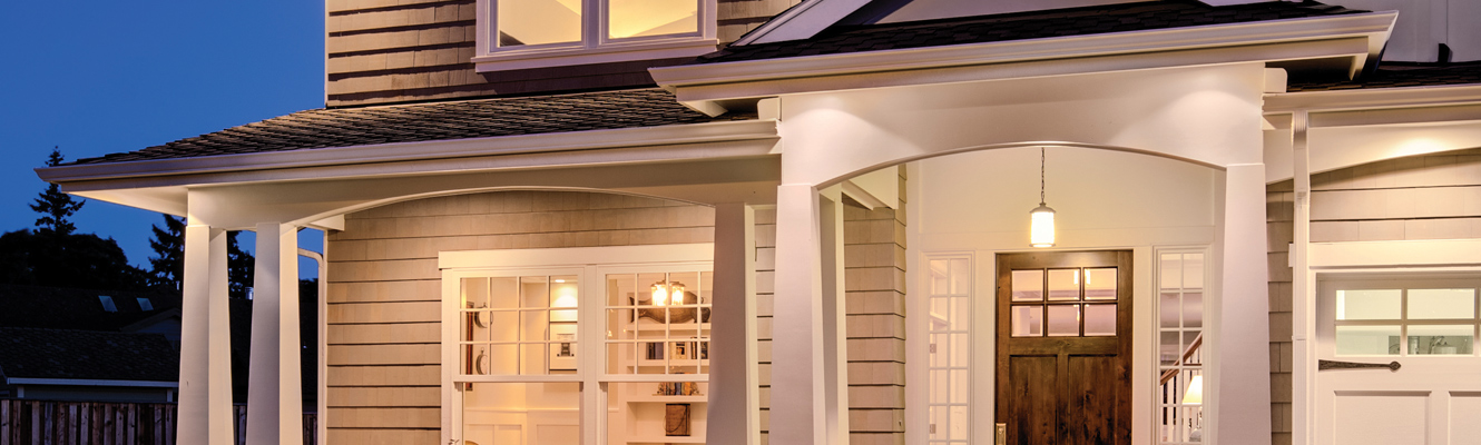 Photo of front porch of home lit up at dusk