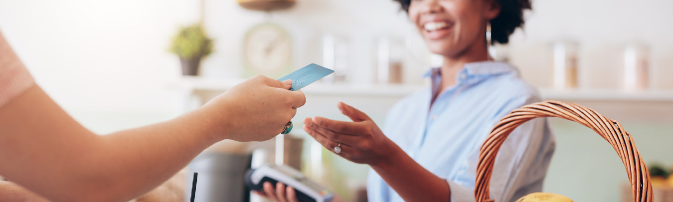 A woman handing her card to a store clerk 