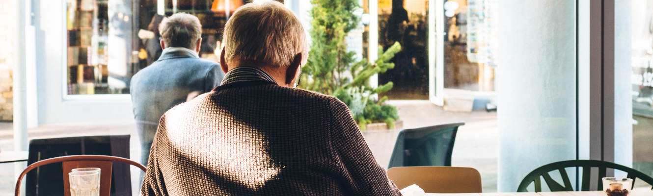 Looking over the shoulder of a man at a cafe.