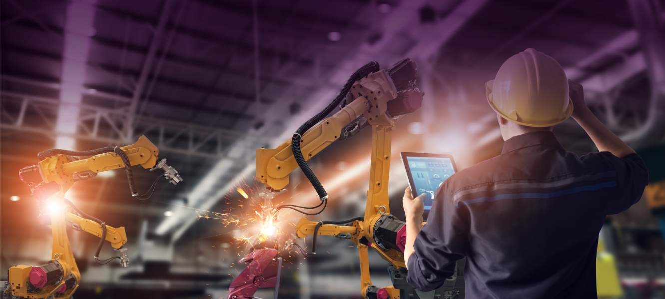 Manufacturing image with worker operating robotic equipment.