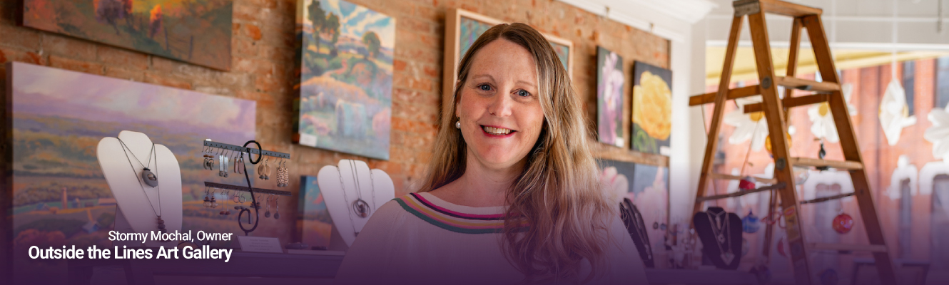 Stormy Mochal standing in her store Outside the Lines Gallery
